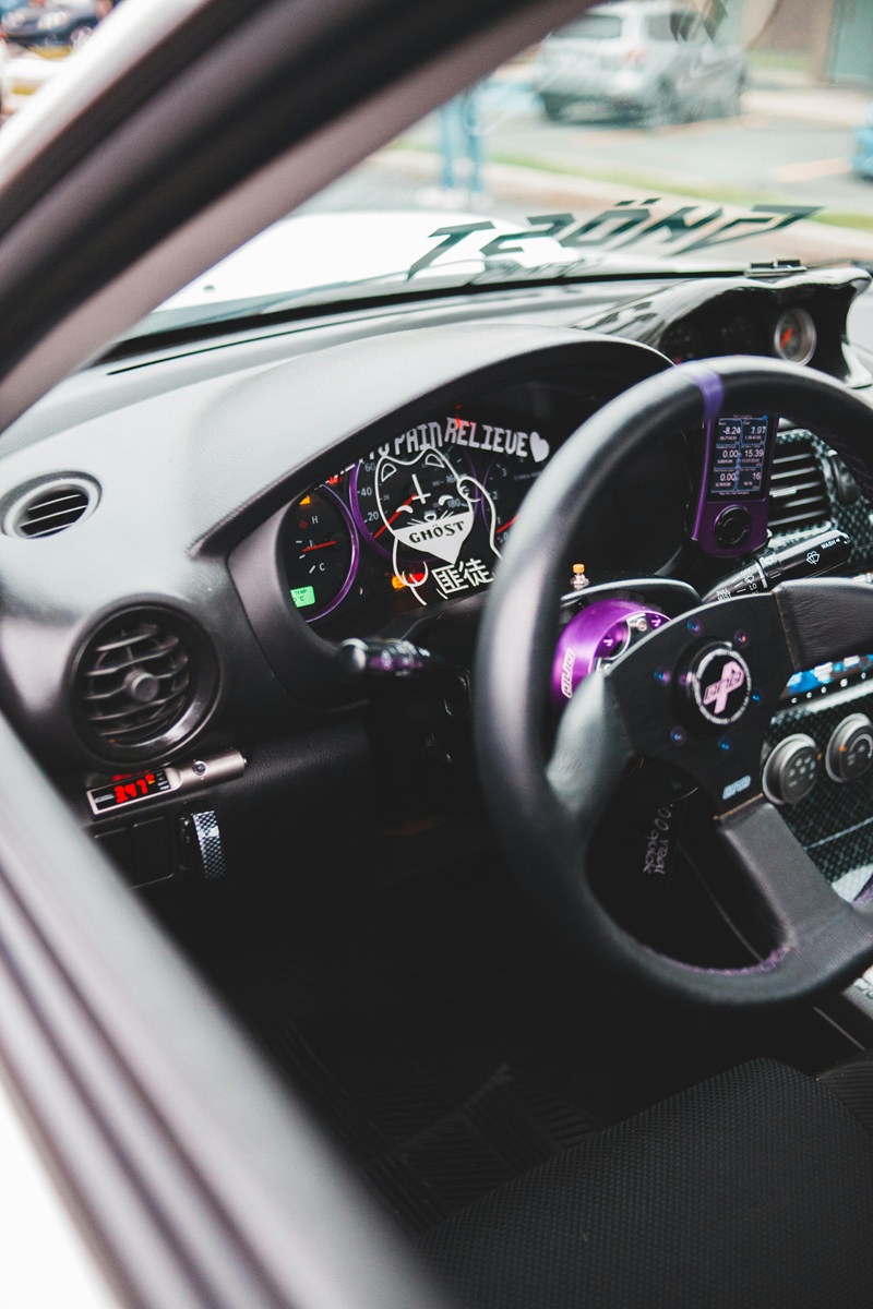 Custom upholstered sports steering wheel in tuned car interior
